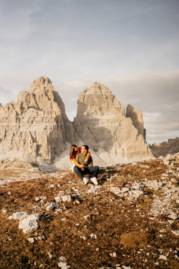 Couple embracing near mountains at sunset.