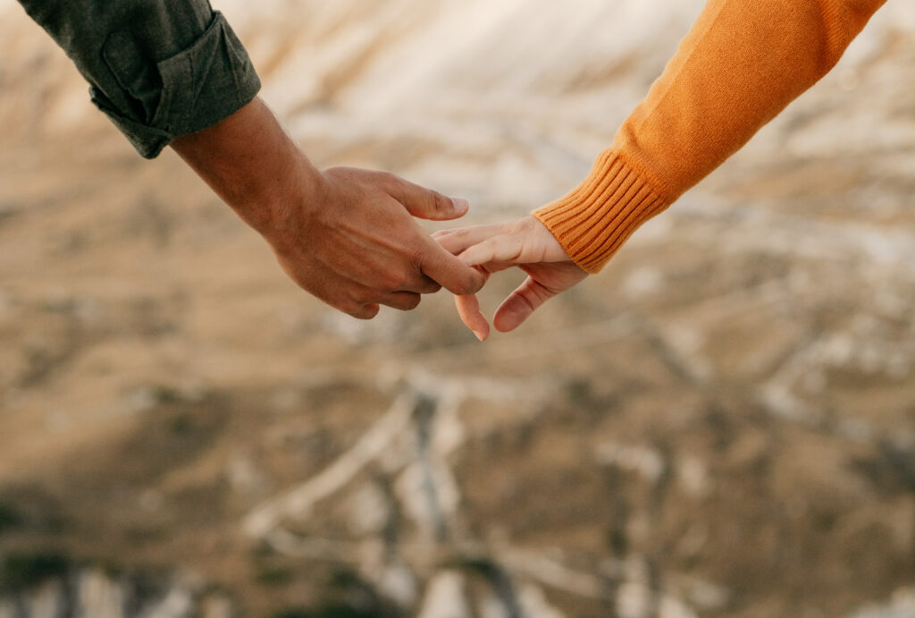 Two people holding hands outdoors