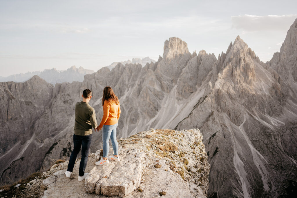 Couple holding hands on mountain cliff edge