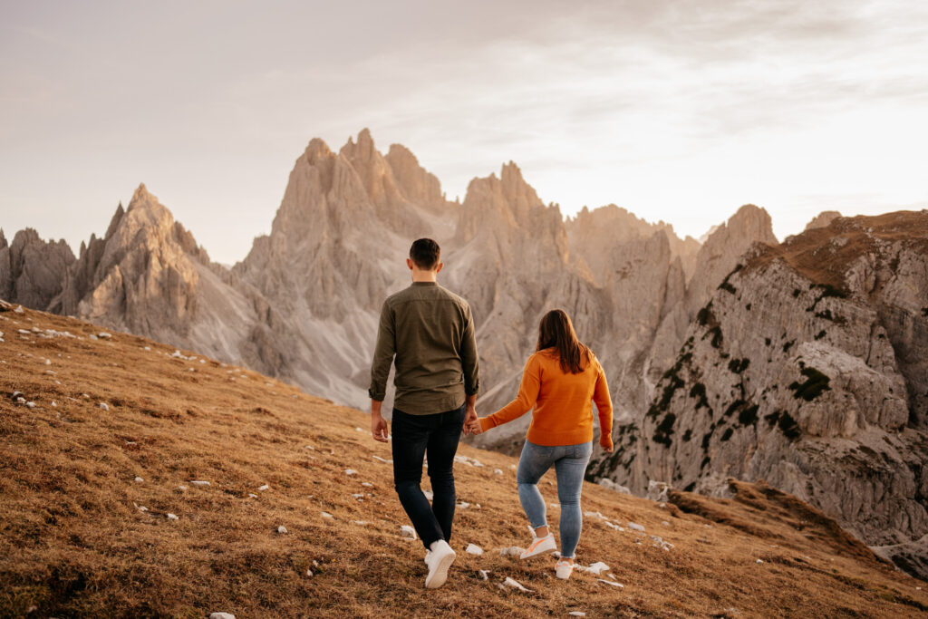 Couple walking on mountain hike at sunset.