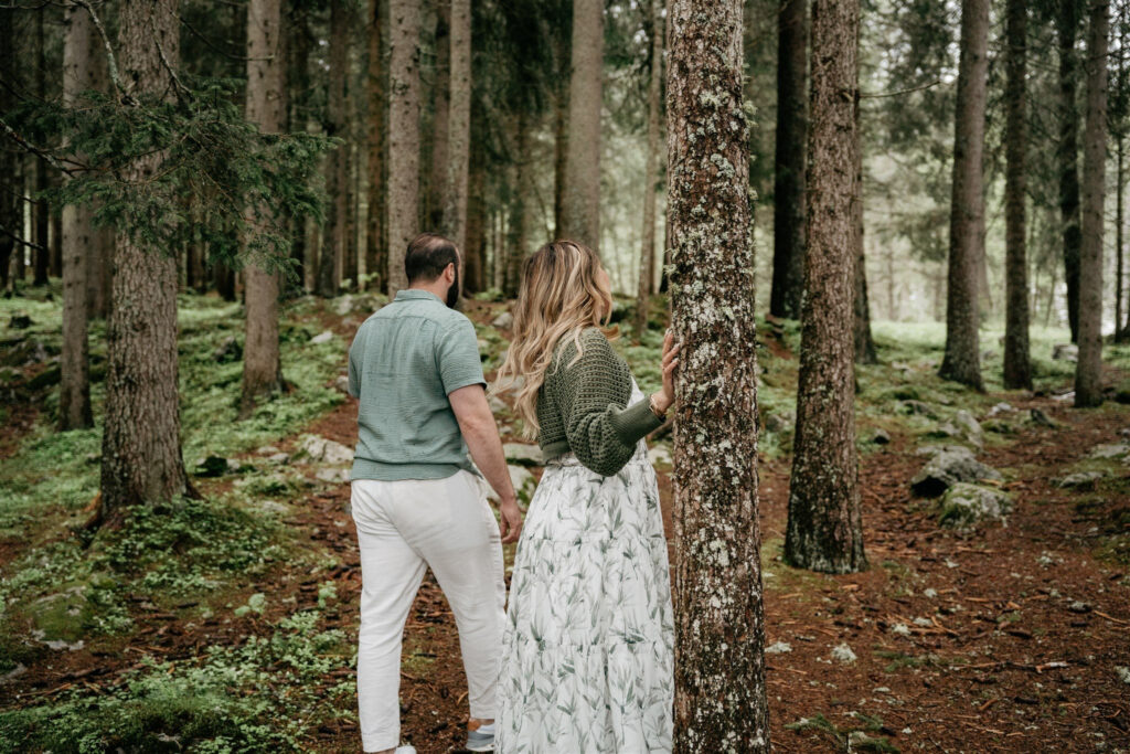 Couple walking through dense green forest