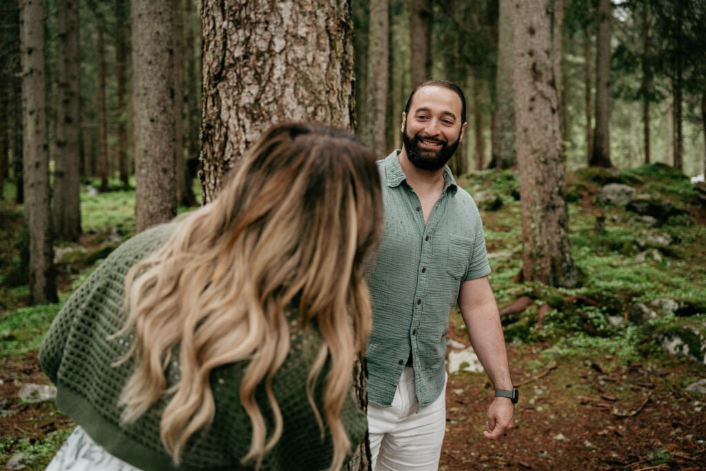 Couple smiling in a forest.