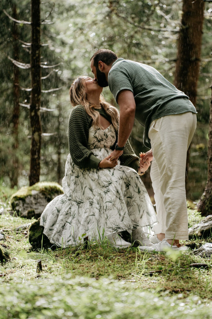 Couple kissing in forest rain