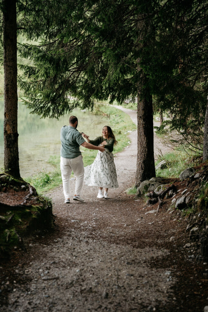 Couple dancing joyfully on a forest path