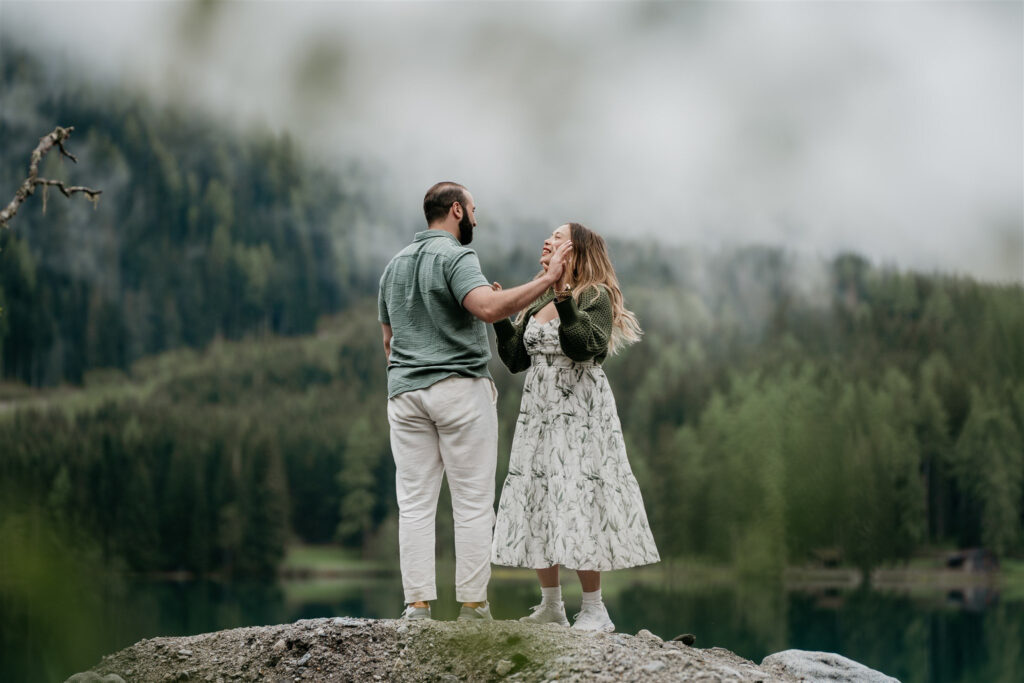 Couple standing together by a scenic lake.