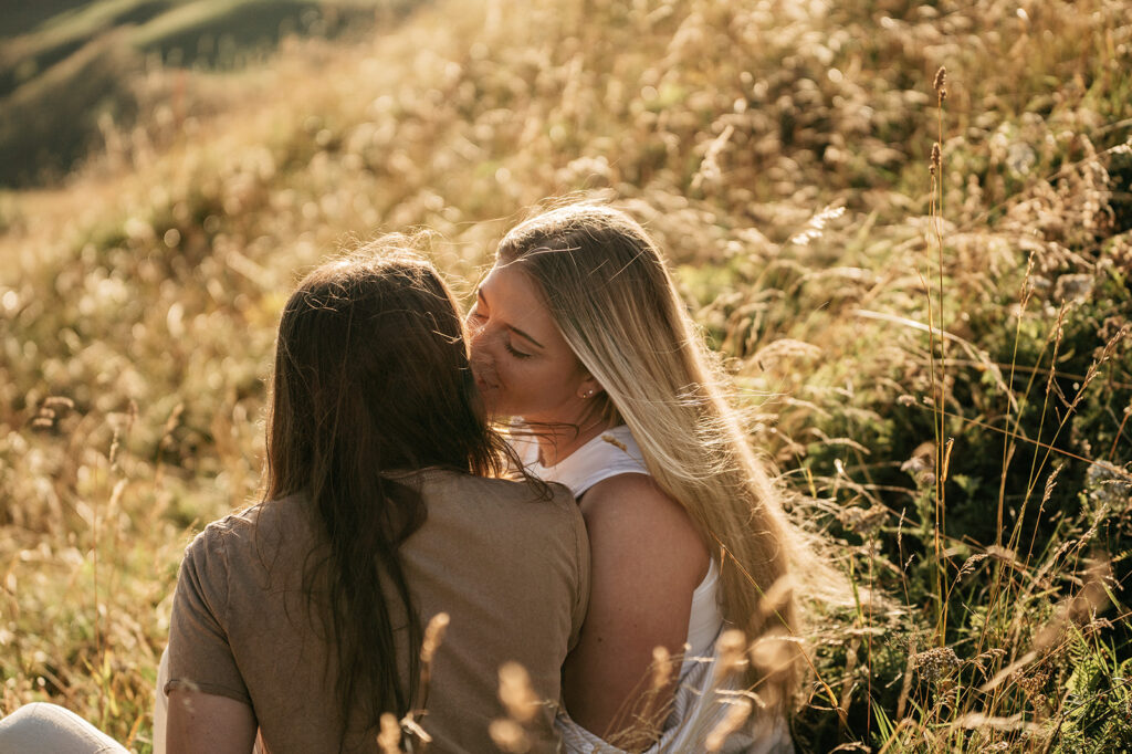 Couple sitting together in a grassy field.