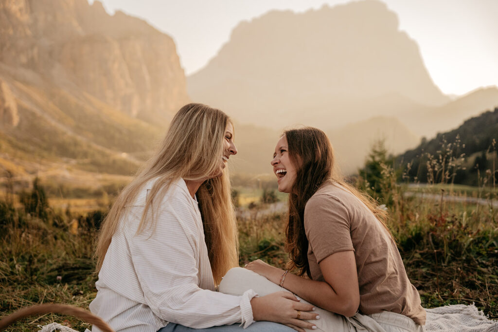 Two friends laughing in scenic mountain setting