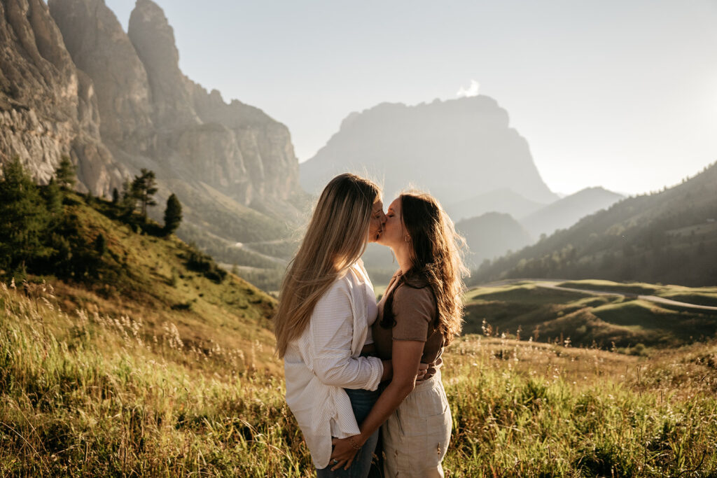 Couple kissing in scenic mountainous landscape.