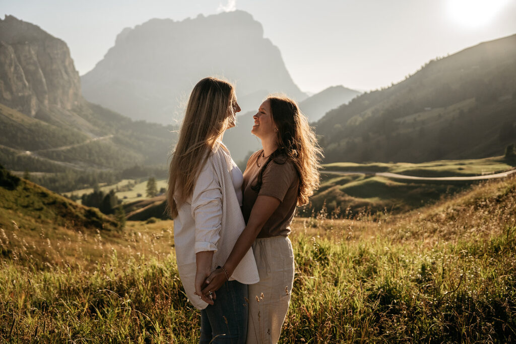 Couple laughing in mountain landscape at sunset.