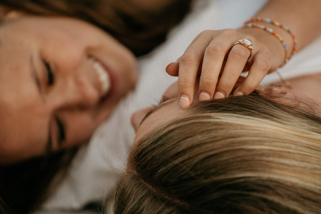 Woman gently touching another's hair, smiling.