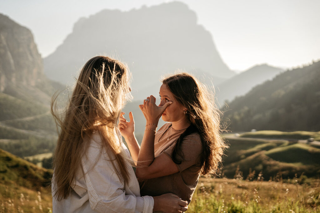 Two women outdoors in a scenic mountain view.