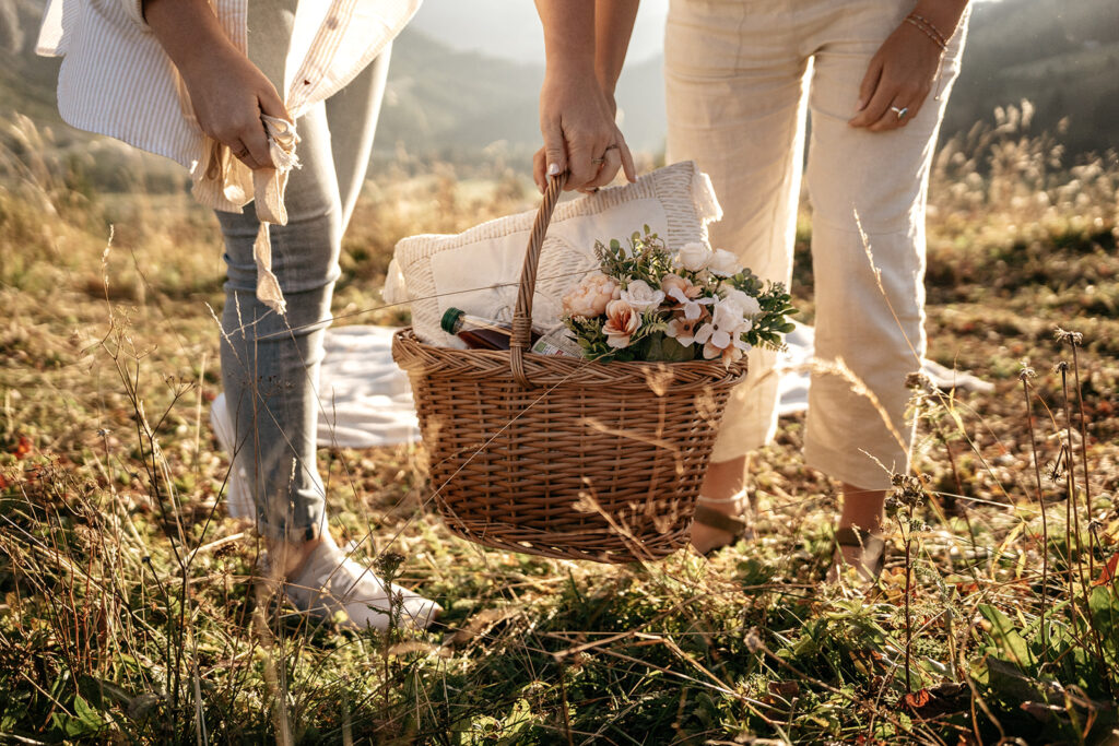 Two people with picnic basket in field