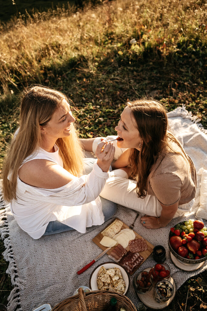 Two women enjoying picnic on a sunny day.