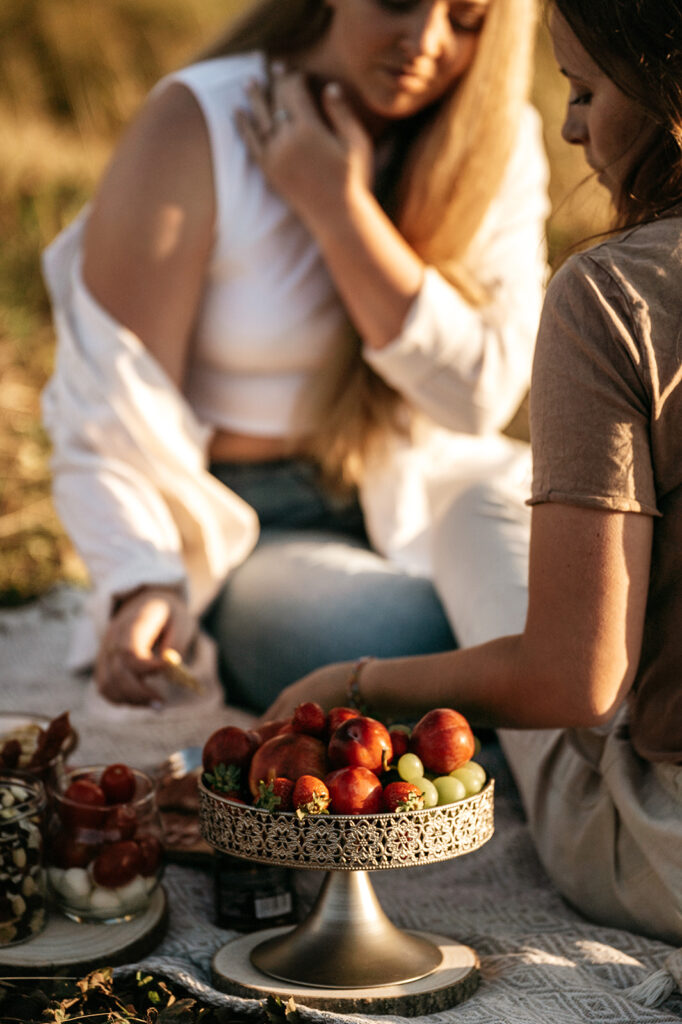 Picnic with fruits and friends in sunlight.