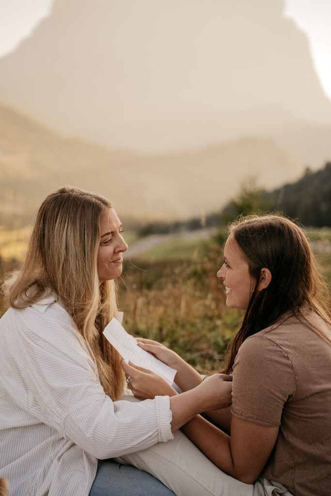 Two women smiling with a letter outdoors.