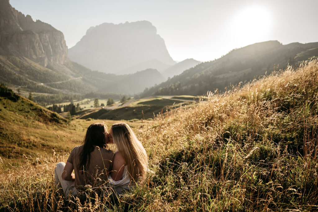 Couple embracing in scenic mountain landscape at sunset.