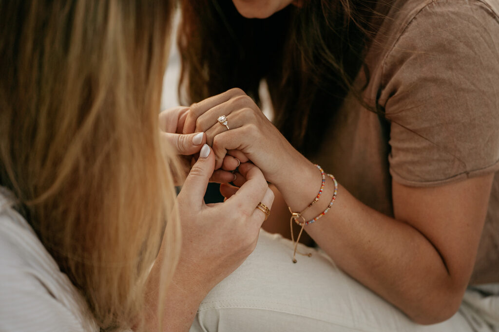 Close-up of hands with engagement ring.