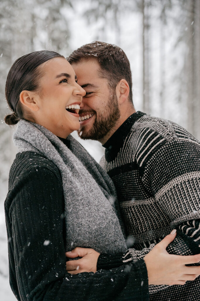 Couple laughing together in snowy forest