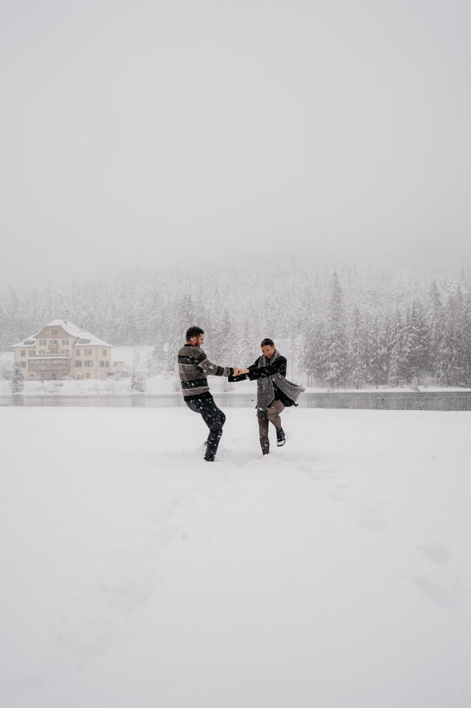 Two people playing in snowy winter landscape.