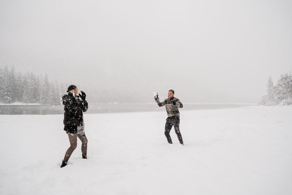 People having a snowball fight in snowy landscape.