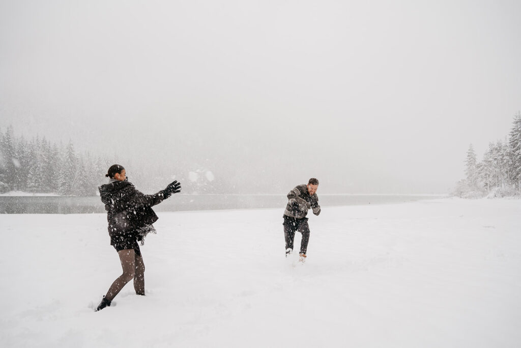 Two people having snowball fight in winter landscape.