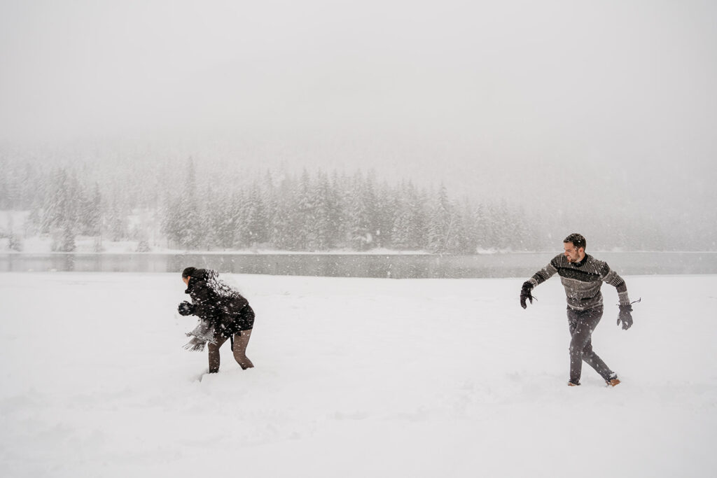 Two people playing in snowy landscape.