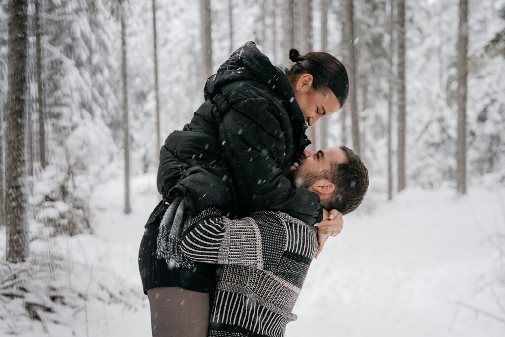 Couple hugging in snowy forest