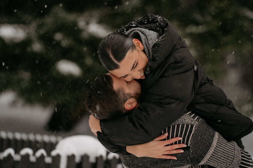 Couple hugging in snowy winter setting.