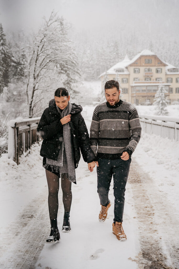 Couple walking in snowy winter landscape.