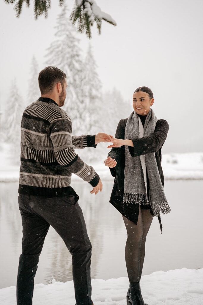 Couple enjoying snowy day by the lake.