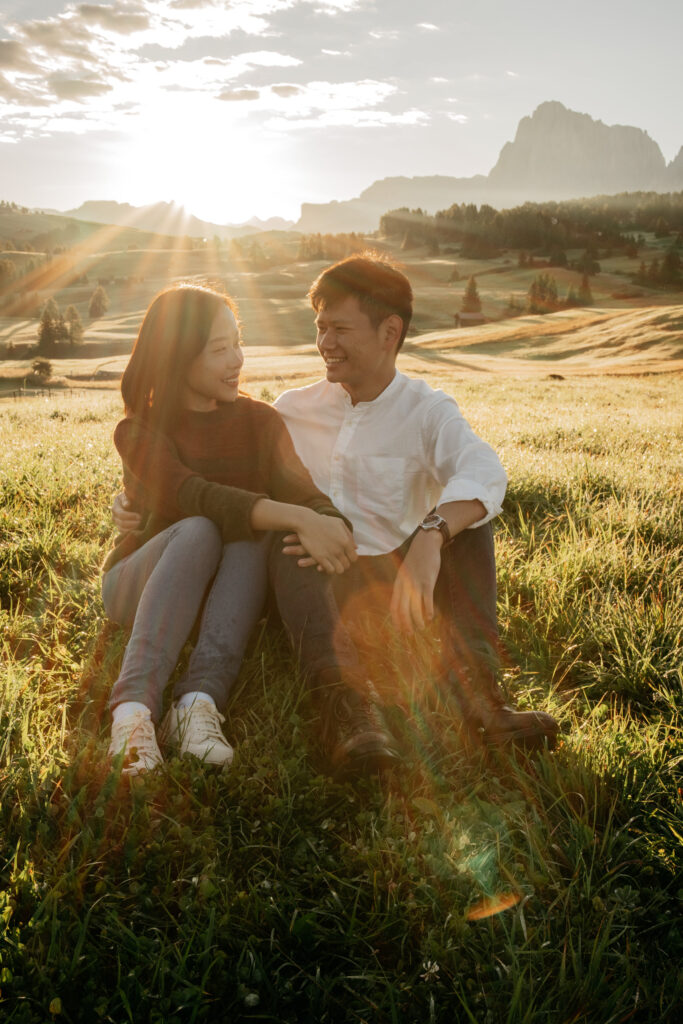 Couple sitting in sunny meadow at sunset