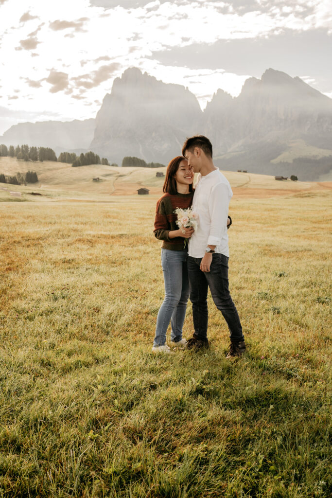 Couple embracing in scenic mountain landscape.