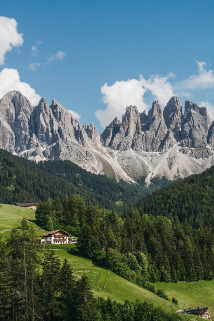 Scenic mountains with lush green forest and cottage.