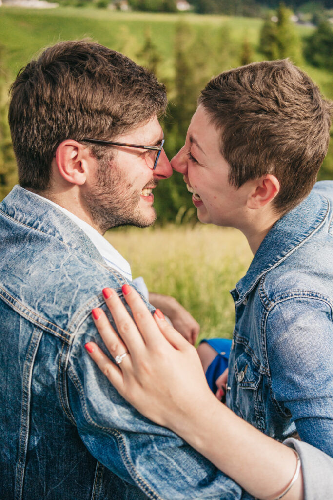 Couple laughing in a field wearing denim jackets.