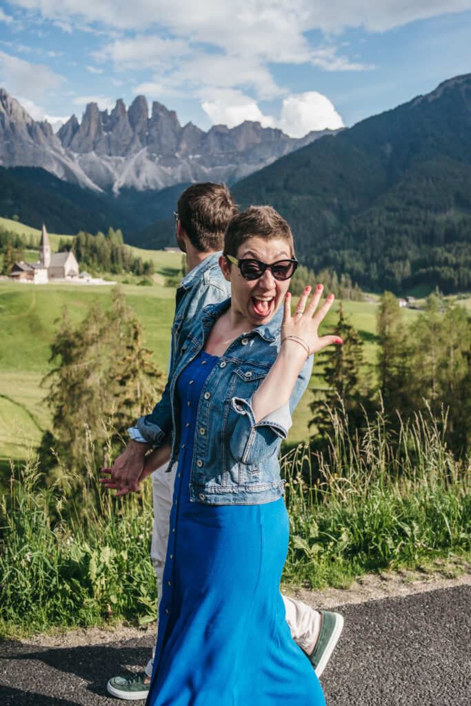 Excited woman showing ring in mountain setting