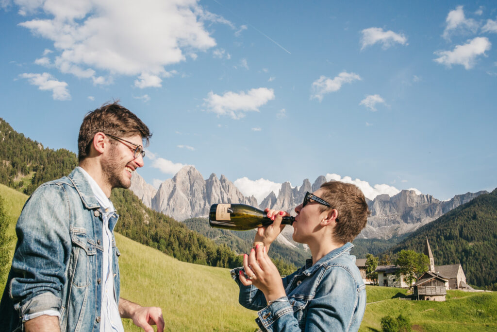 Friends enjoying wine in beautiful mountain landscape.