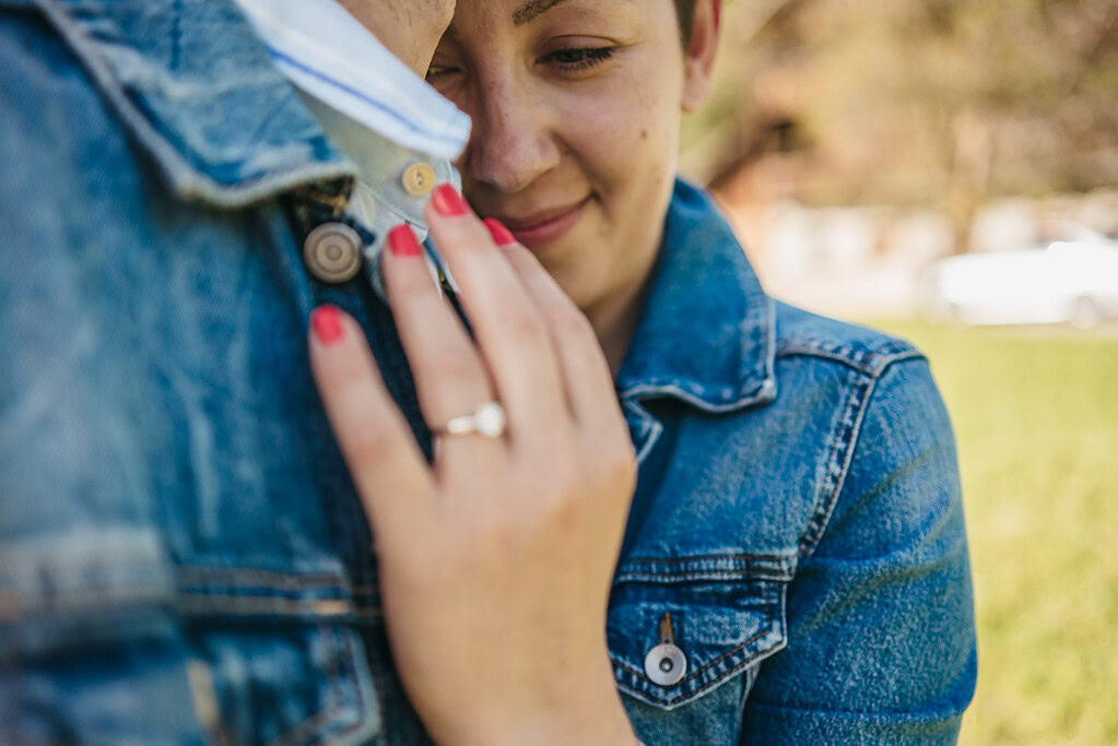 Closeup of couple hugging in denim jackets.