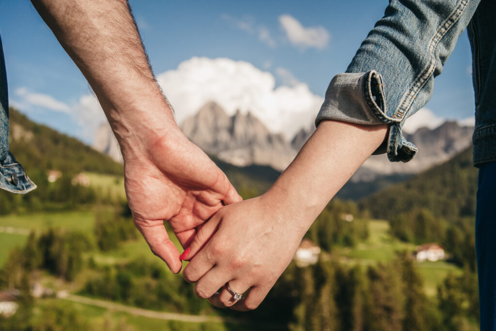 Couple holding hands in scenic mountain landscape