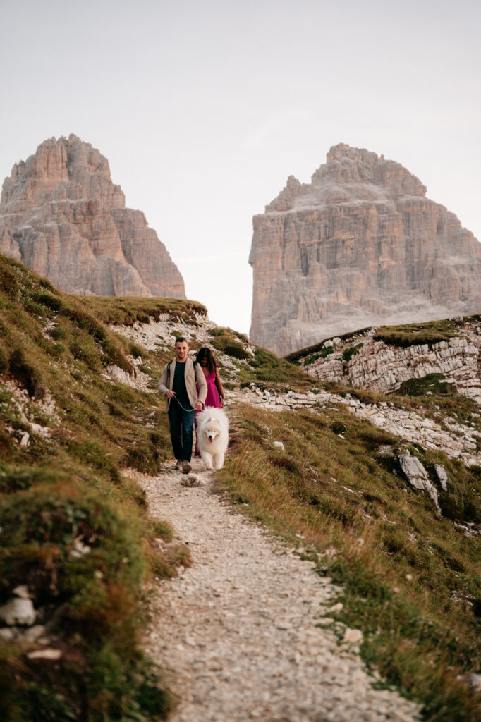 Couple walking dog in mountain landscape