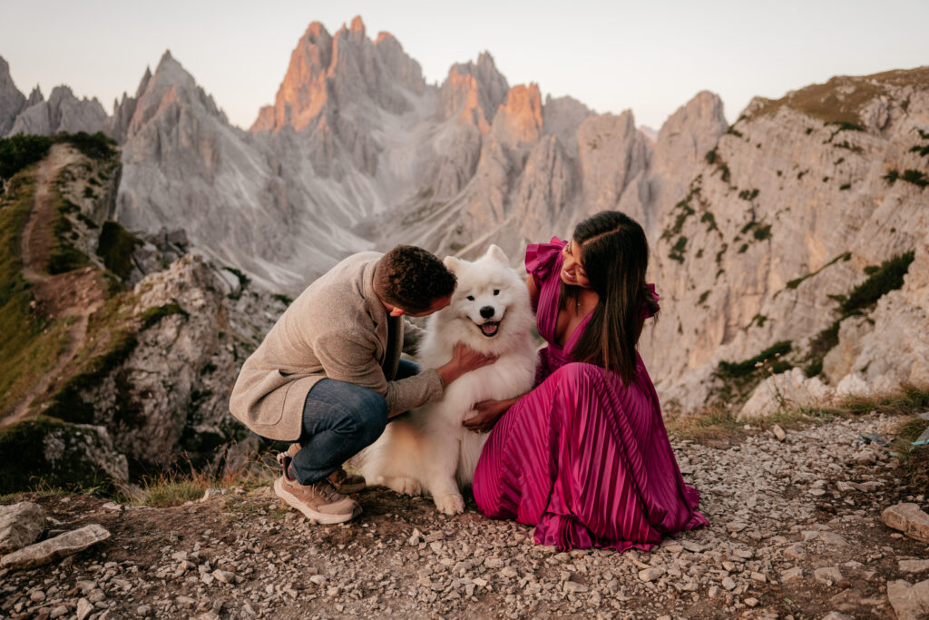 Couple hugging dog in mountain landscape