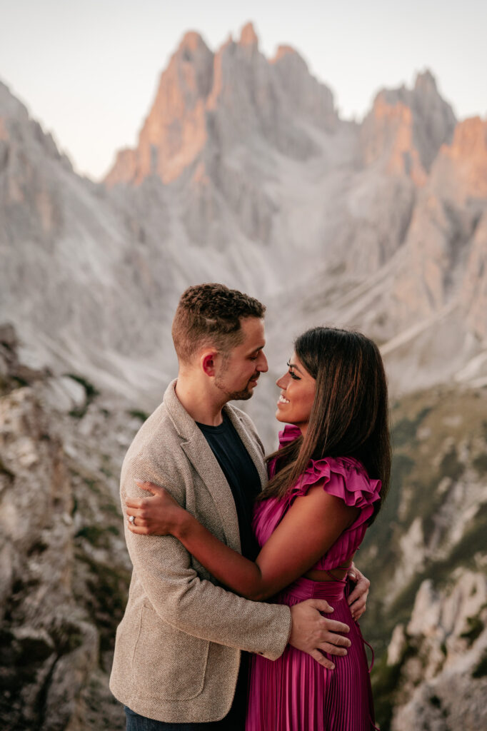 Couple embracing with mountain backdrop at sunset