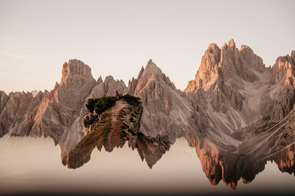 Mountain peaks reflecting in tranquil lake at sunset.