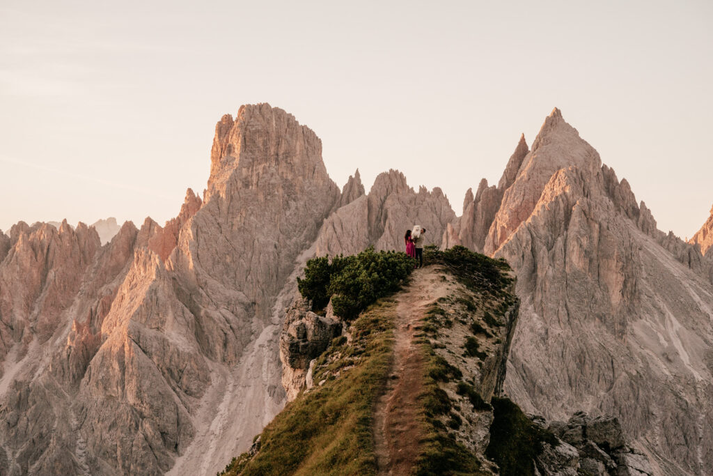 People standing on mountain cliff at sunset