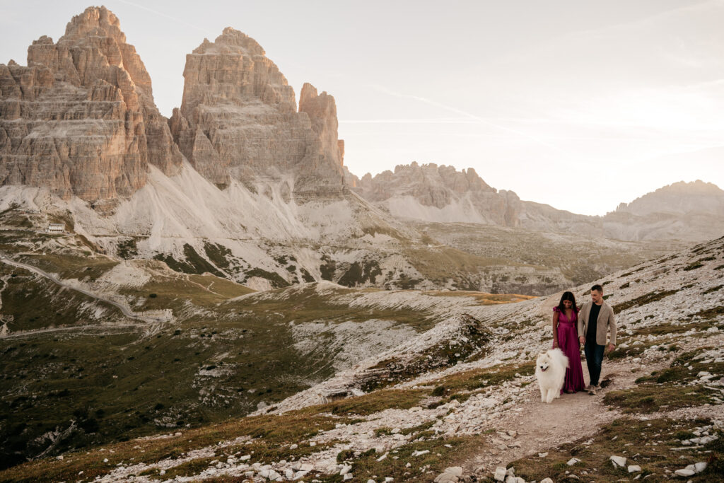 Couple walking with dog near mountain landscape