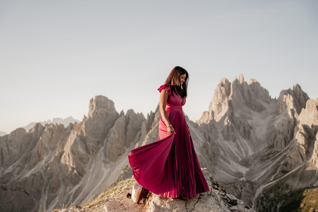 Woman in red dress on mountain peak