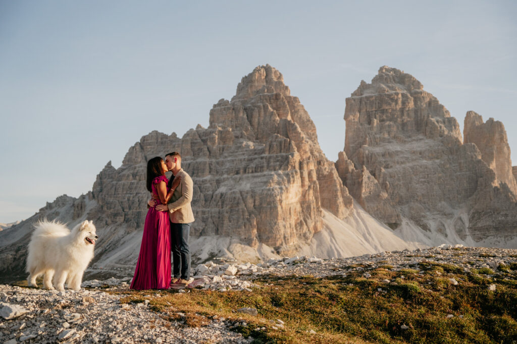 Couple with dog at mountain backdrop kissing