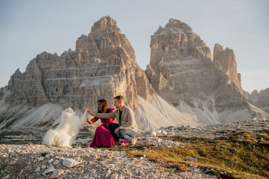 Couple with dog in mountain landscape.