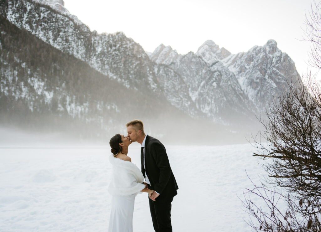 Couple kissing in snowy mountain landscape