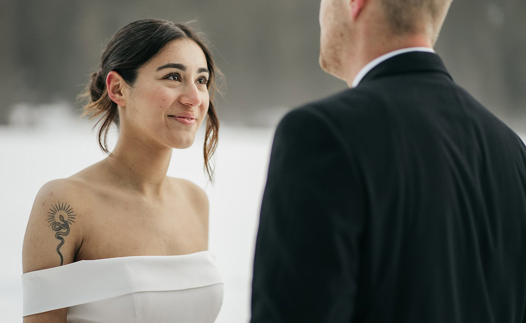 Bride smiling at groom during outdoor ceremony