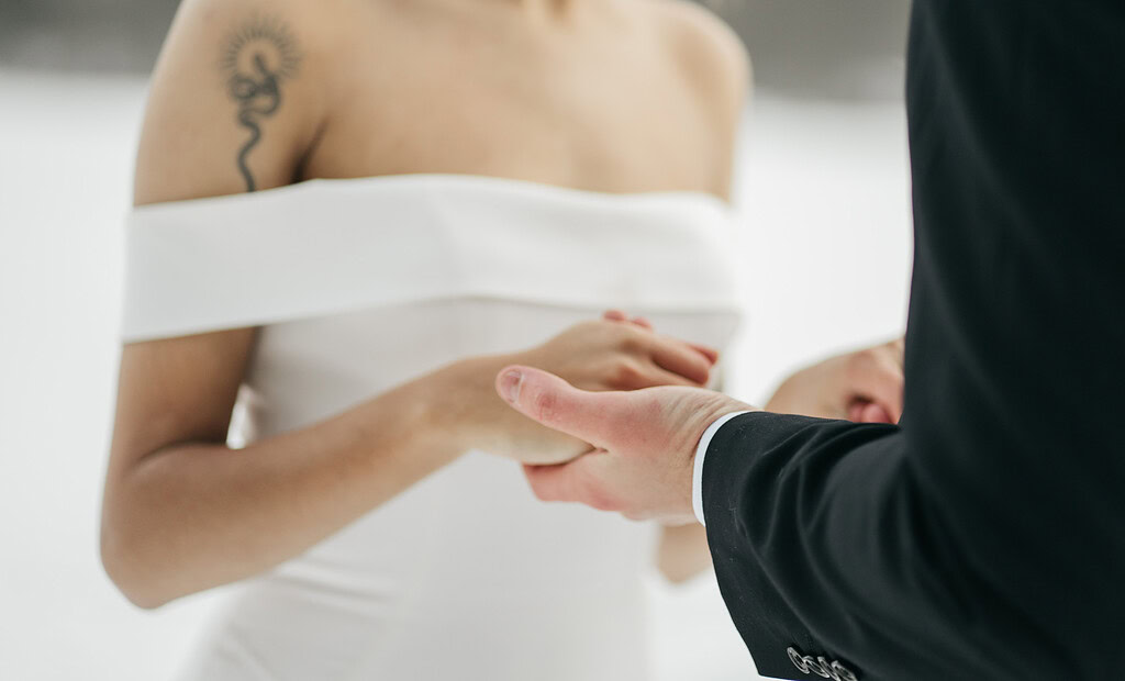 Bride and groom holding hands during ceremony.